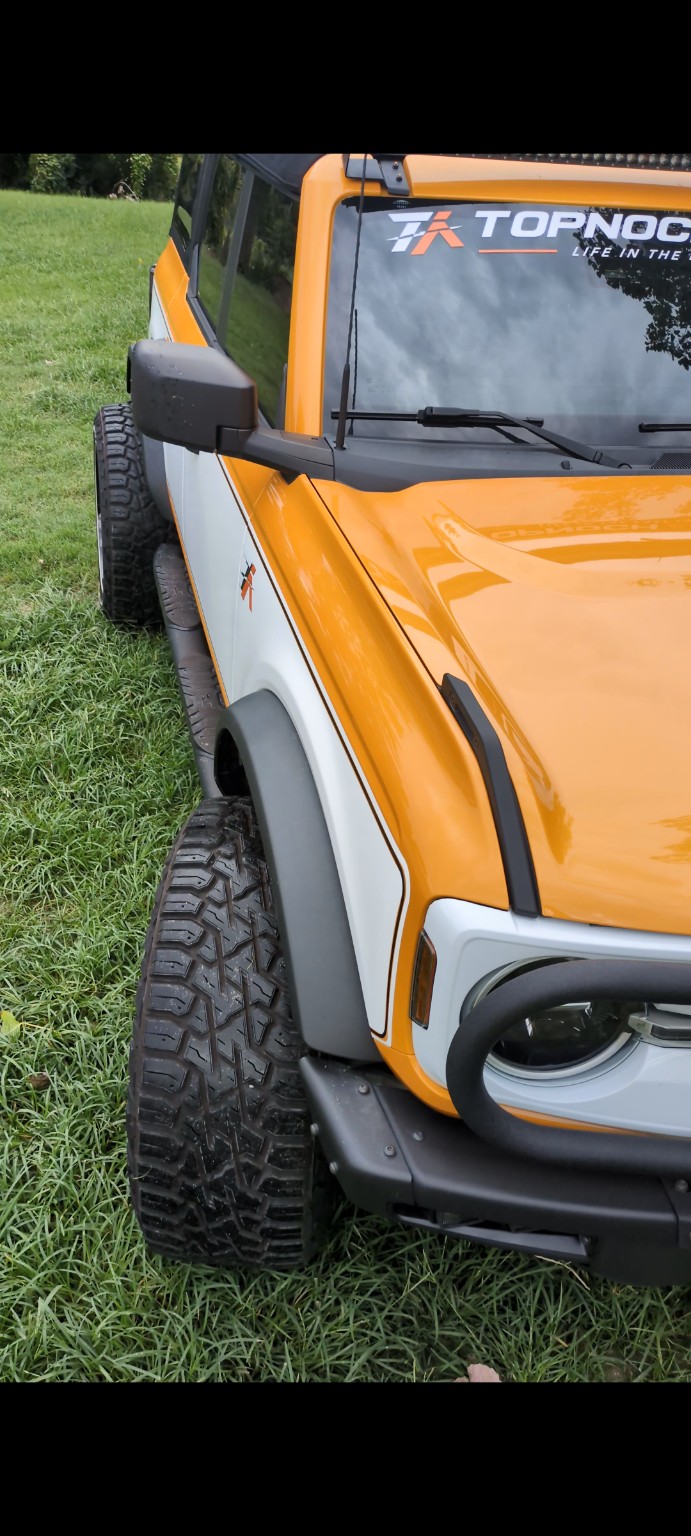 Close view of the Topnochauto Bronco front fender, wheel and custom paint treatment